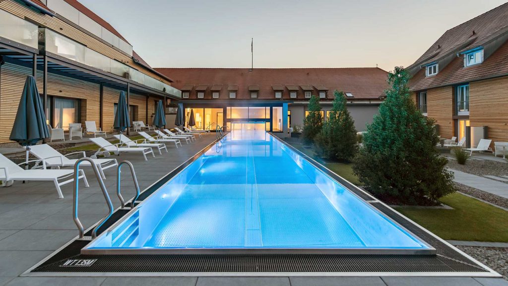 Beleuchteter Infinity Pool im Außenbereich eines Spas. 
