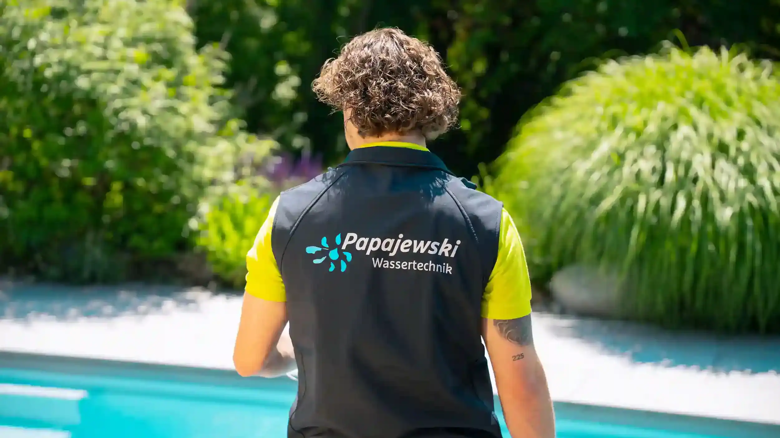 Monteur von Papajewski Wassertechnik steht am Pool und blickt ins Wasser.