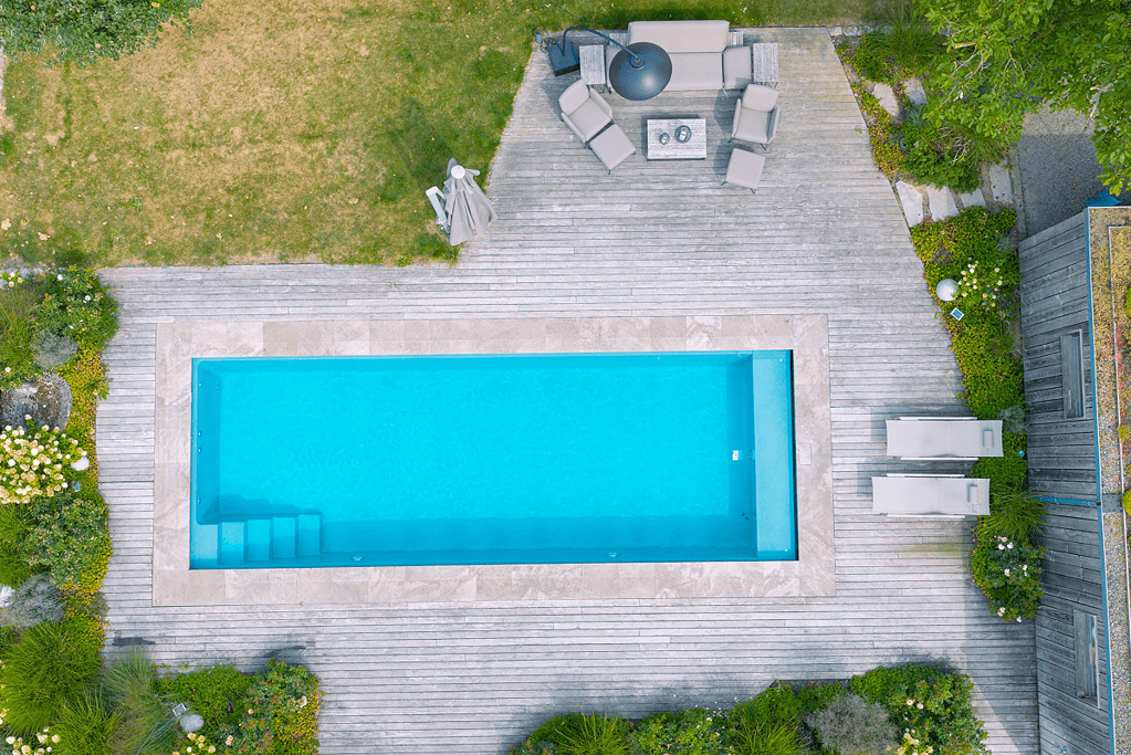 Poolbau mit modernem Holzdeck und rechteckigem Pool aus der Drohnenperspektive