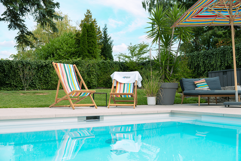 Pool Referenz mit sommerlichen Gartenpool mit bunten Liegestühlen und gepflegter Bepflanzung
