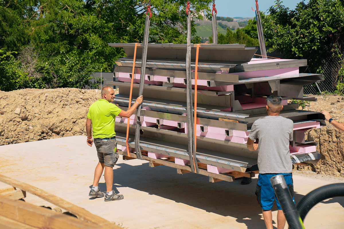 Poolbau Team bringt großformatige Stahlbauteile auf die Baustelle im Garten