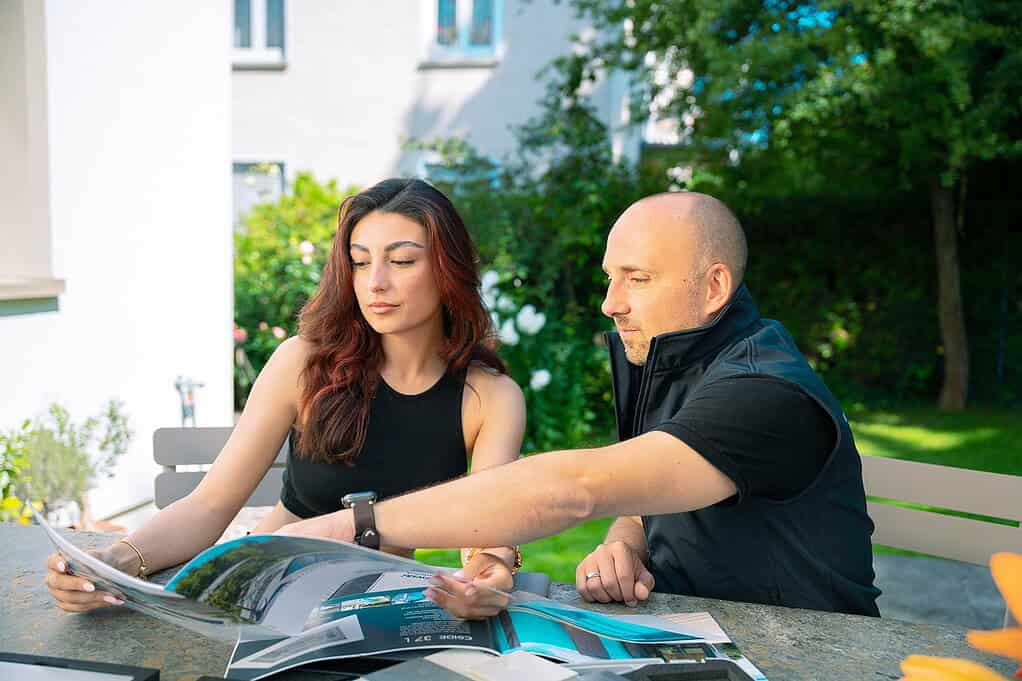 Poolbauer Stephan Papajewski berät eine Kundin über Abdeckungen für ihren Minipool.